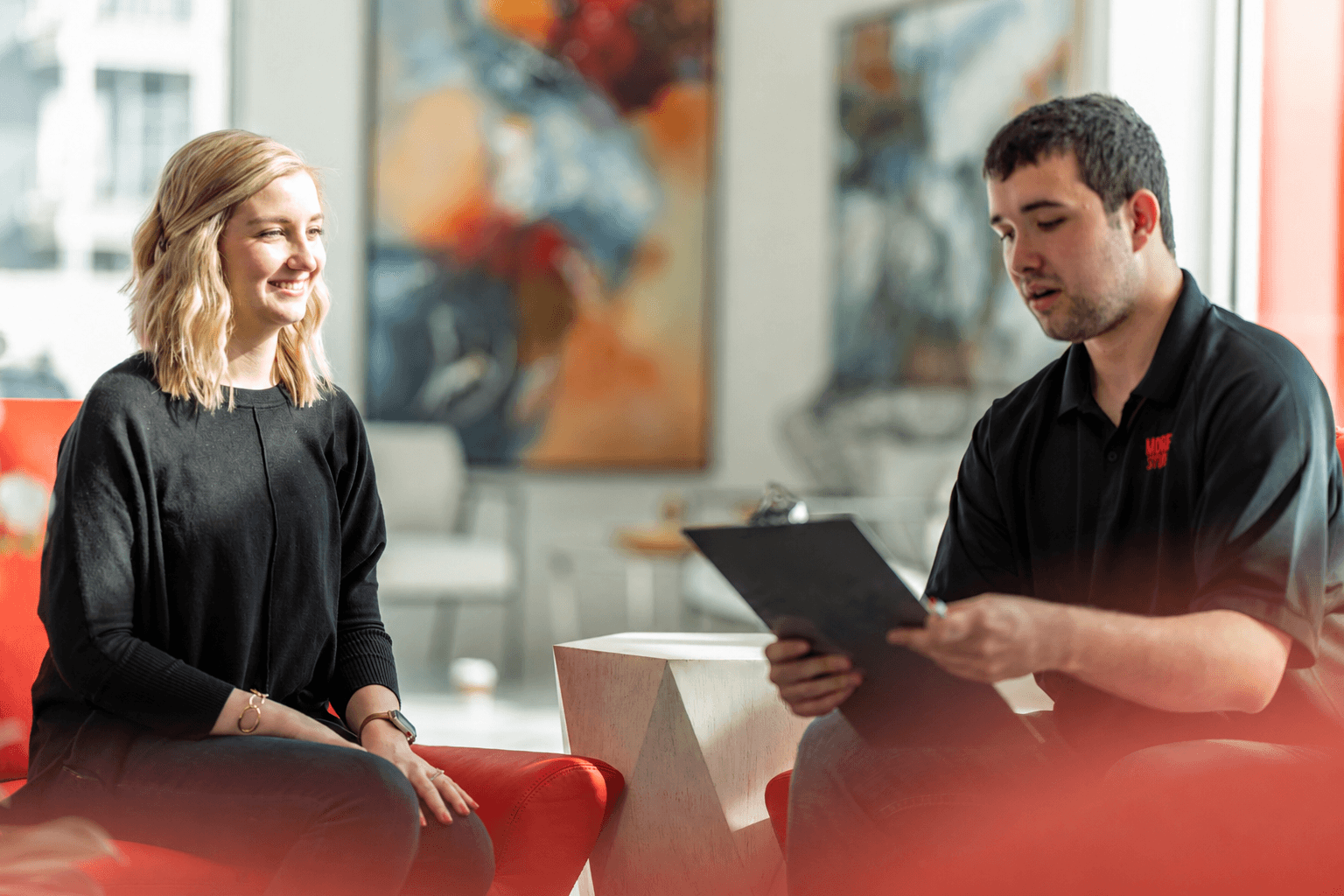 Modern Storage® team member walking a smiling new customer through the storage move-in checklist on a clipboard