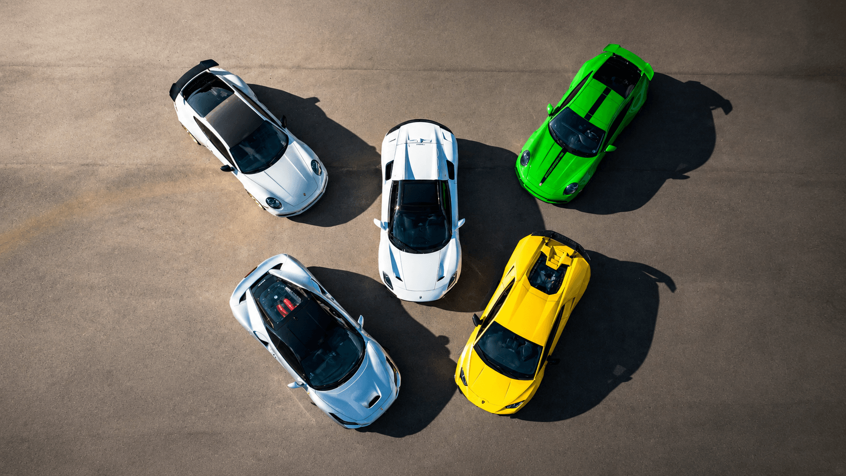 Five collector cars parked in front of red Modern Storage® roll-up doors — Arkansas exotic and collector vehicle storage