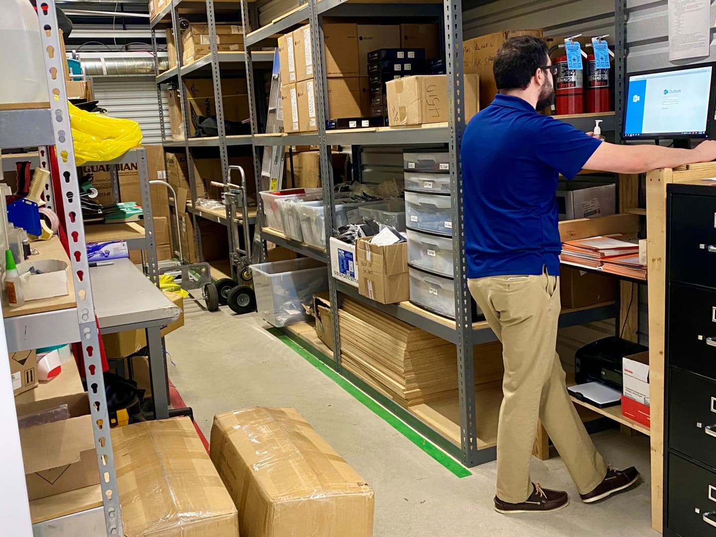 Neatly organized self storage unit with stacked labeled boxes and shelving