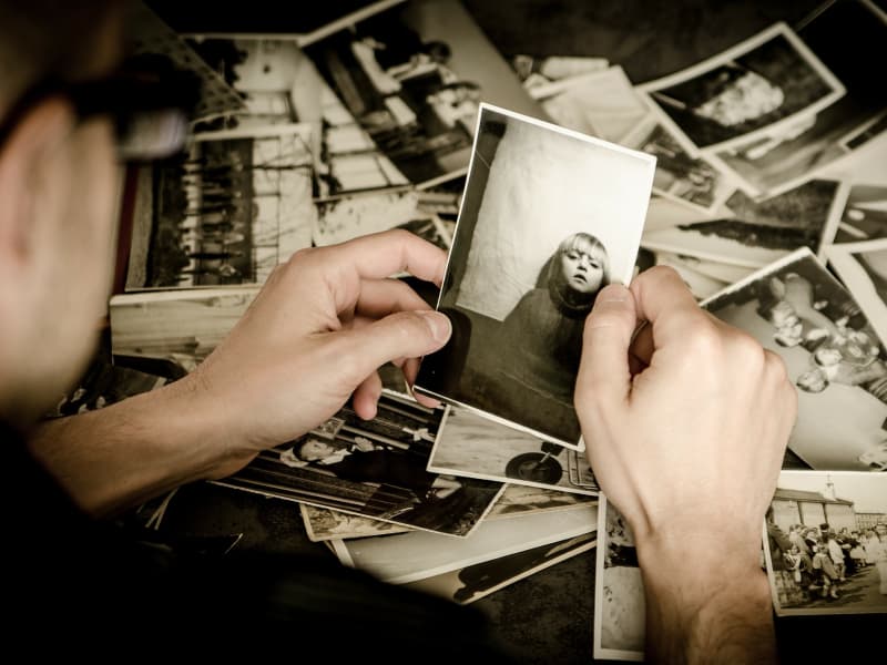 Boxes of old photographs being organized for storage in a storage unit
