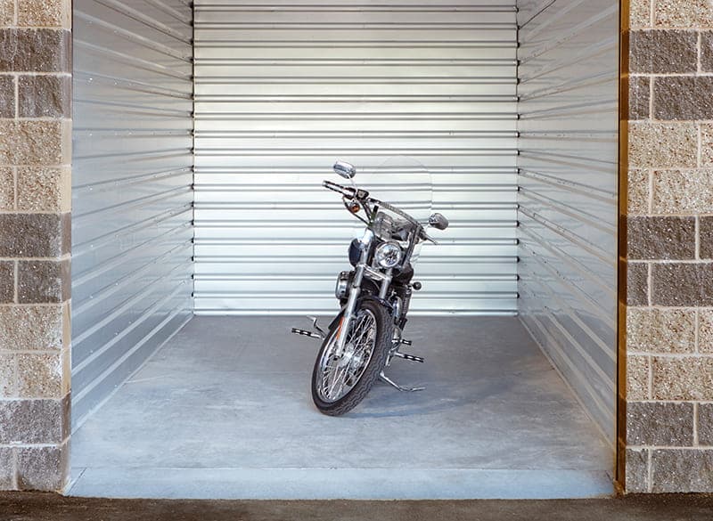 Motorcycle parked inside a clean indoor storage unit with metal walls at Modern Storage®