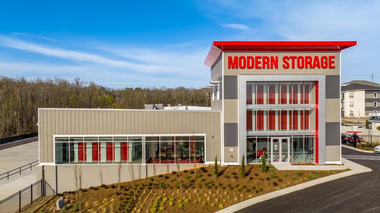 Modern Storage facility in North Little Rock with red accents, glass entry tower, and landscaped front drive