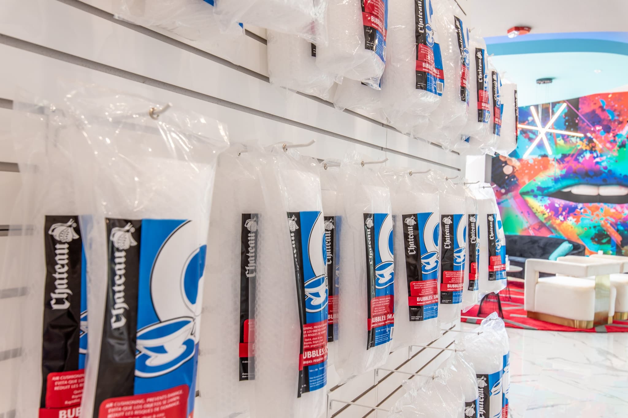 Wall display of bubble wrap rolls at a Modern Storage retail space, offering packing materials to help protect glassware, dishes, and fragile items in storage.