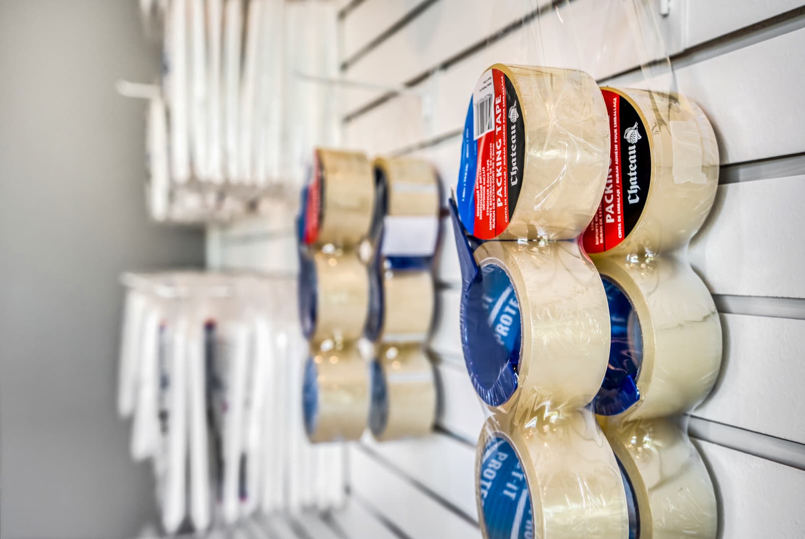 Close-up of packing tape rolls and moving supplies on a retail wall at Modern Storage®, representing essential renter tips and storage do’s and don’ts.