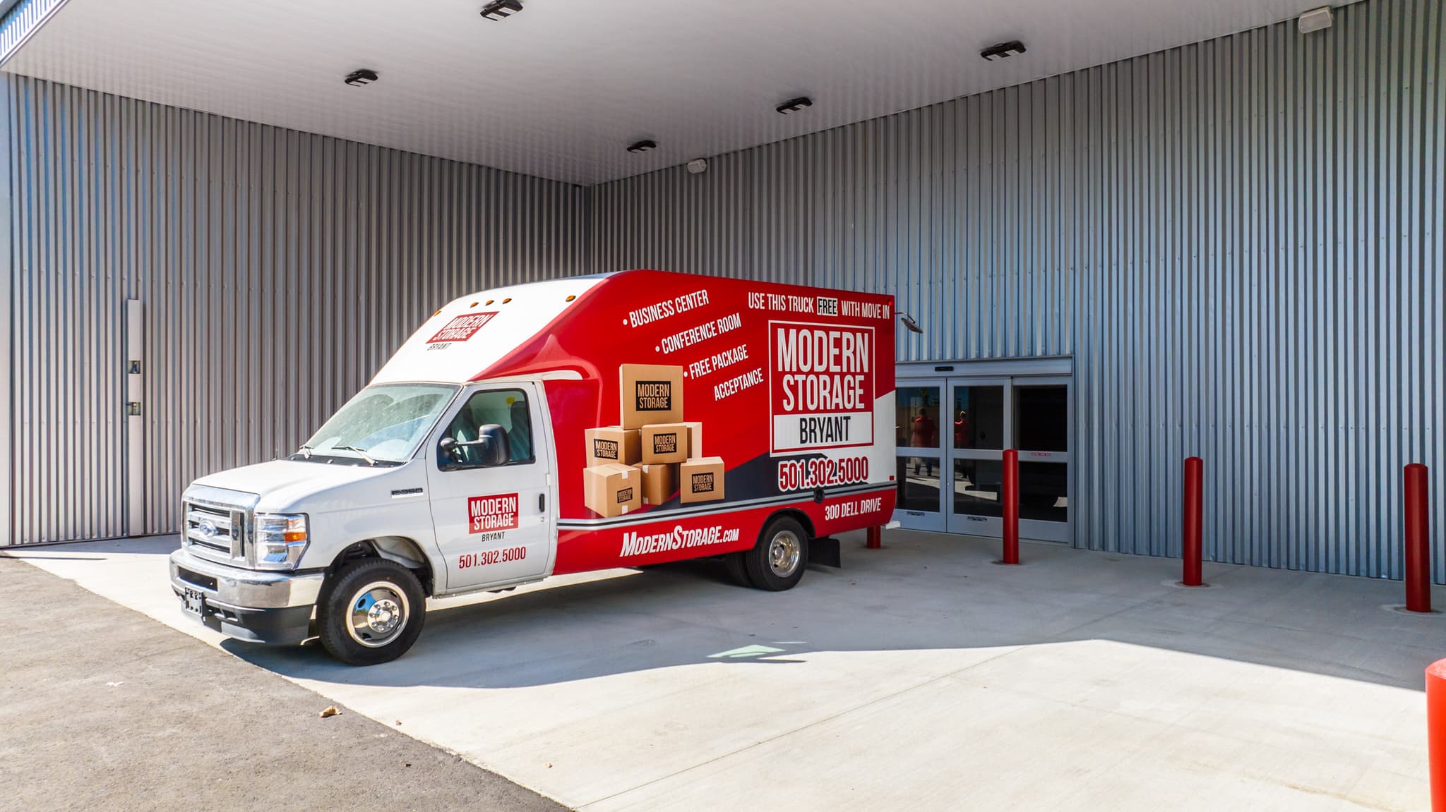 Modern Storage® moving truck parked outside the Bryant facility under a metal awning, offering customers a free truck rental to simplify their move-in.