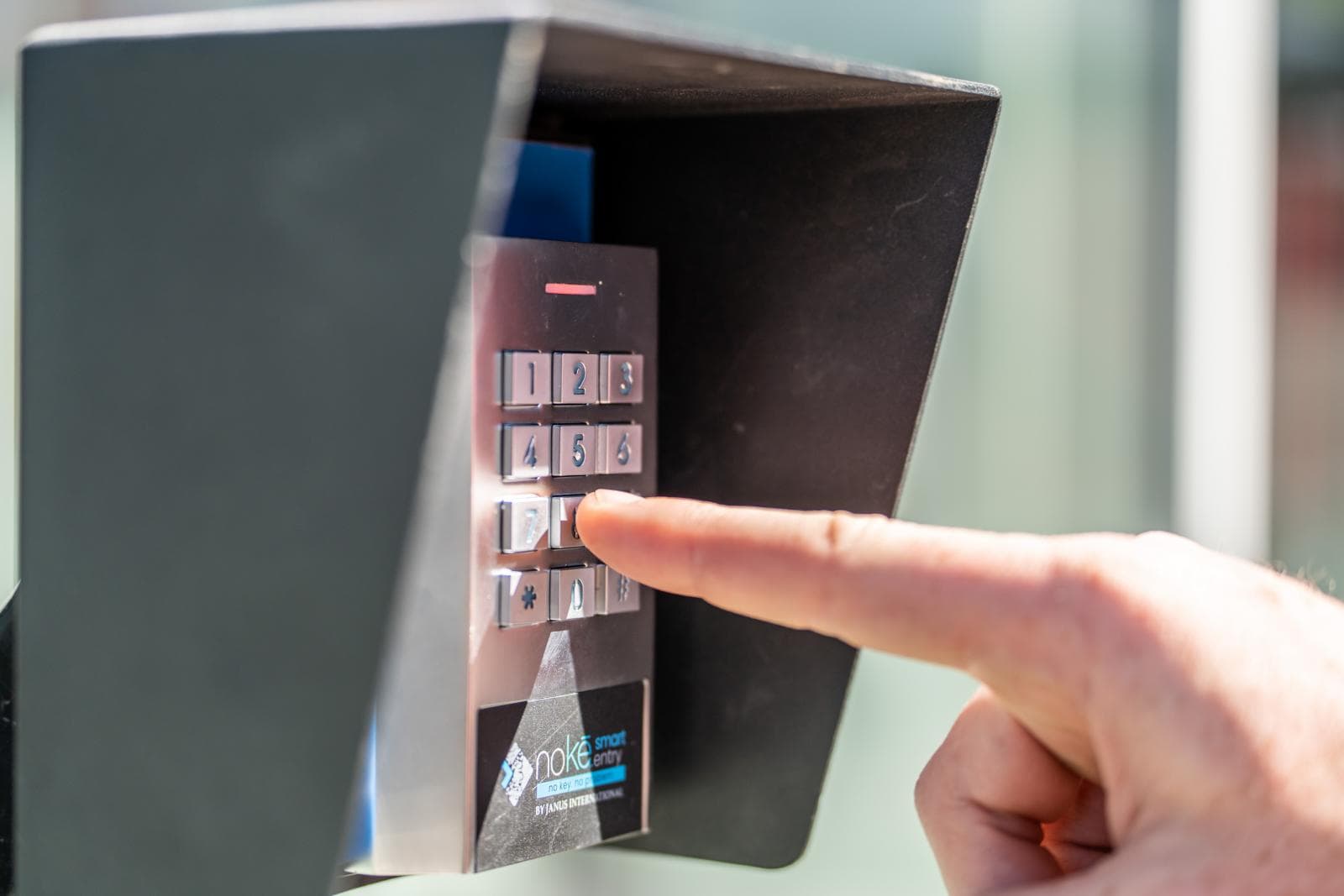 Close-up of a person entering a code on the Modern Storage® Bentonville secure NOKE gate keypad access system
