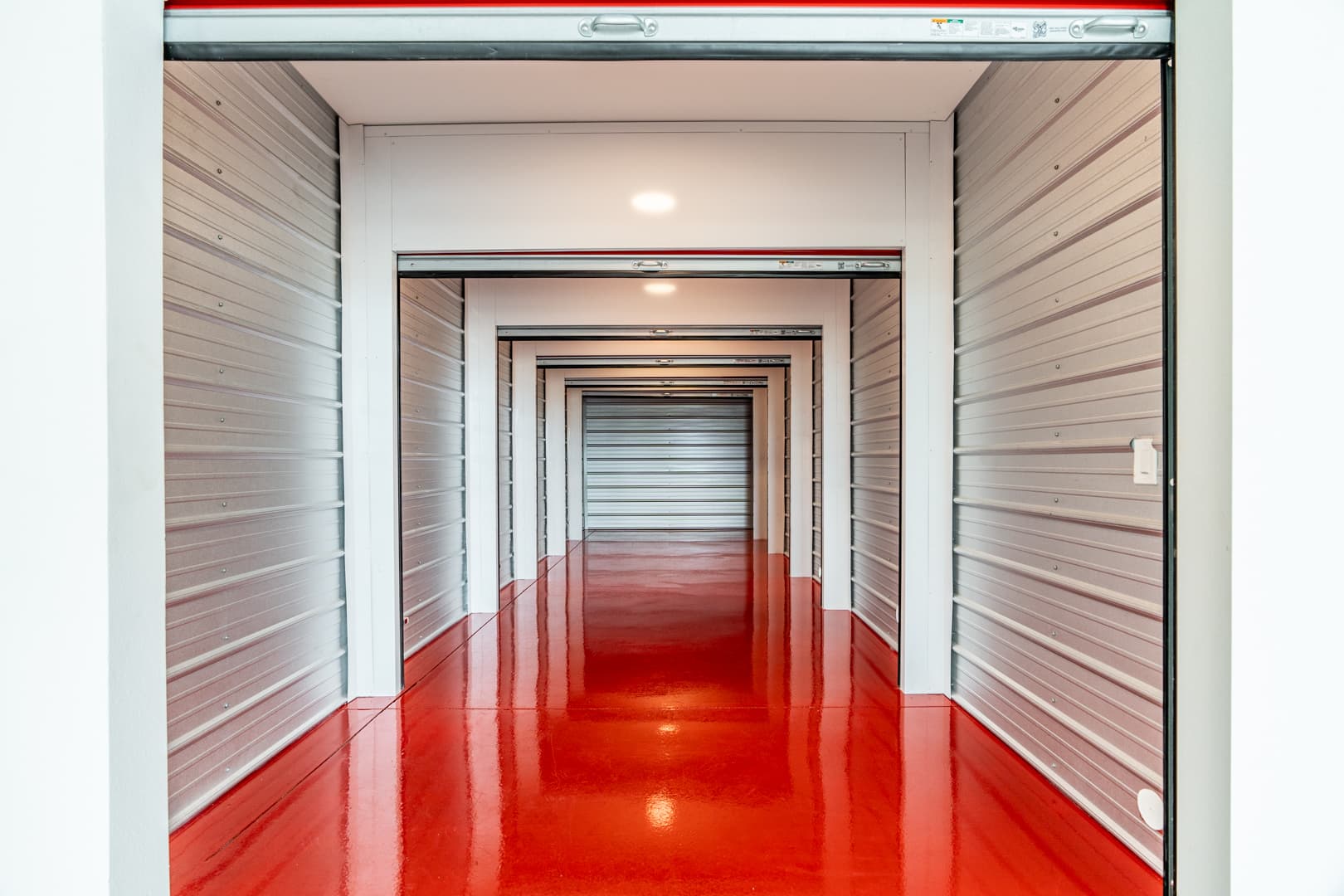Interior hallway of a clean, well-lit Modern Storage® self-storage facility with rows of storage unit doors