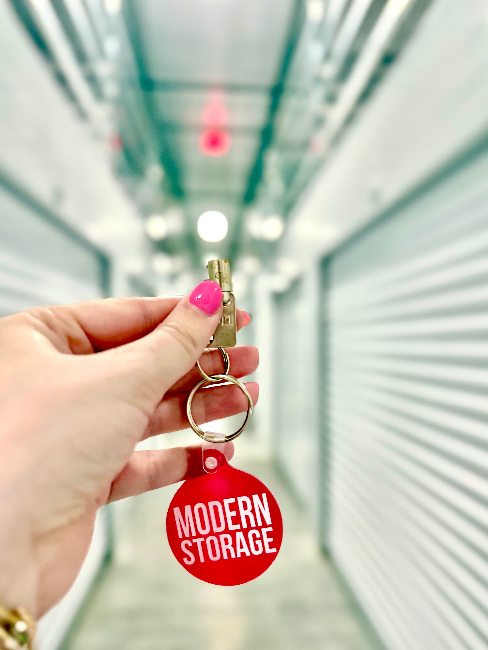 Person holding a Modern Storage® keychain and unit key, symbolizing secure self-storage access