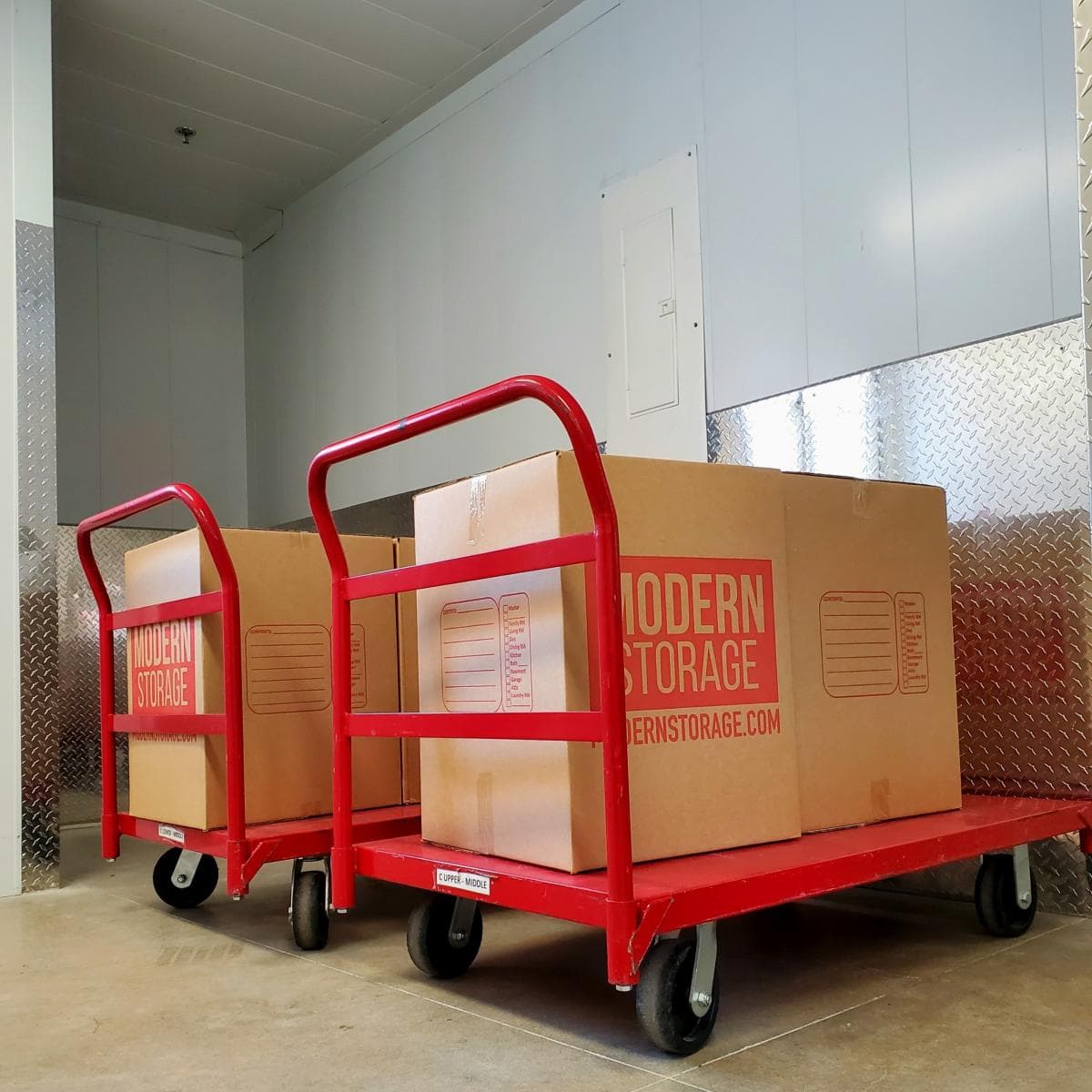 Cardboard boxes stacked on moving carts at a Modern Storage facility