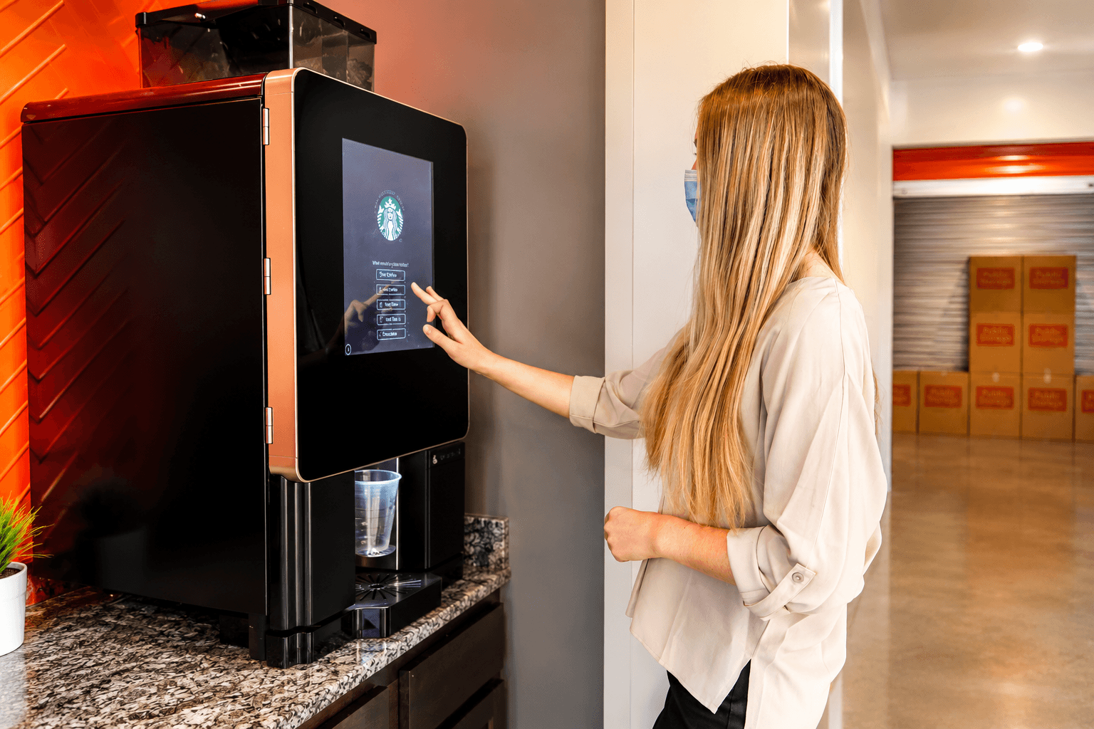 Customer using the Starbucks coffee station inside a Modern Storage facility
