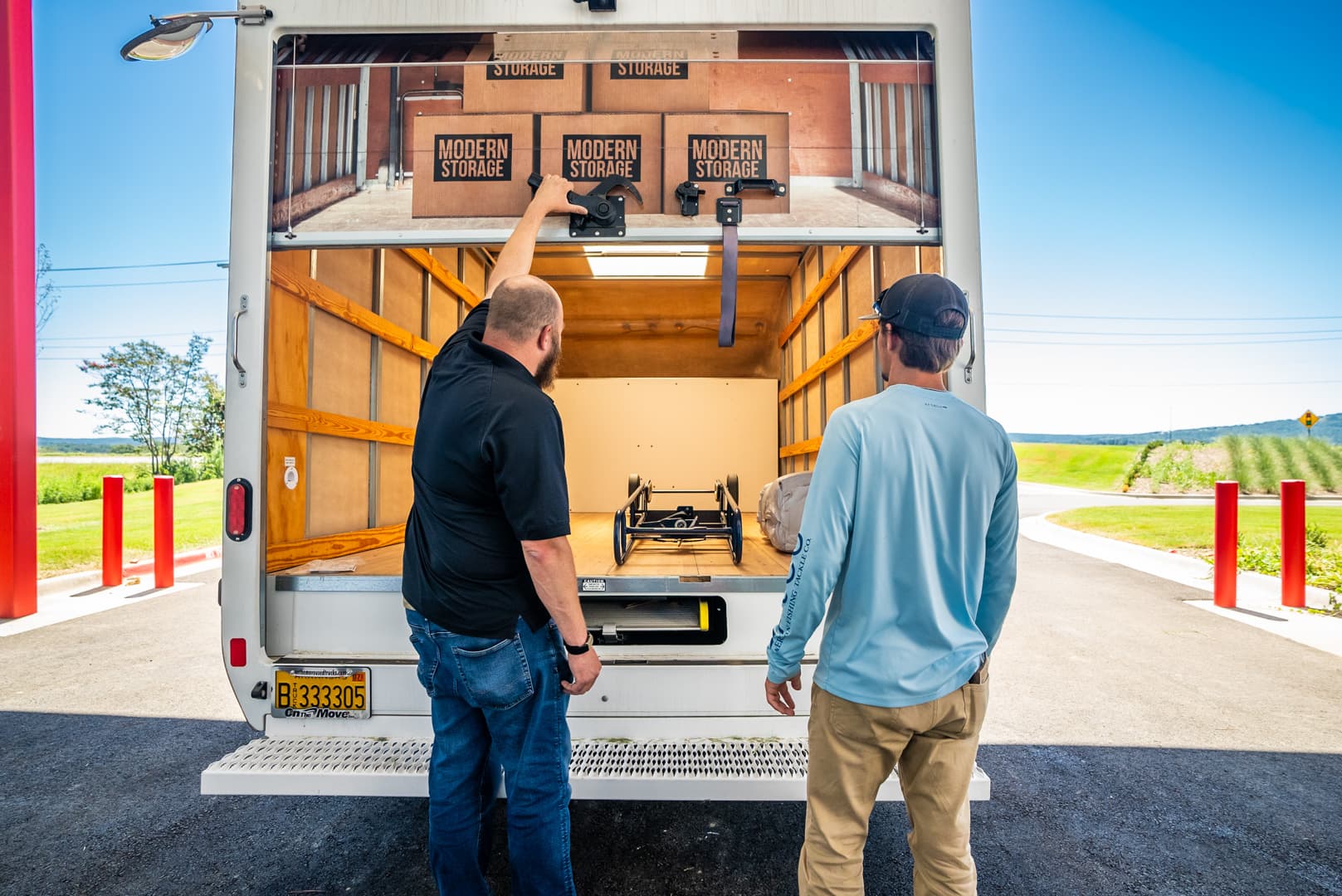 Two men unloading a moving truck filled with Modern Storage® boxes at a self-storage facility