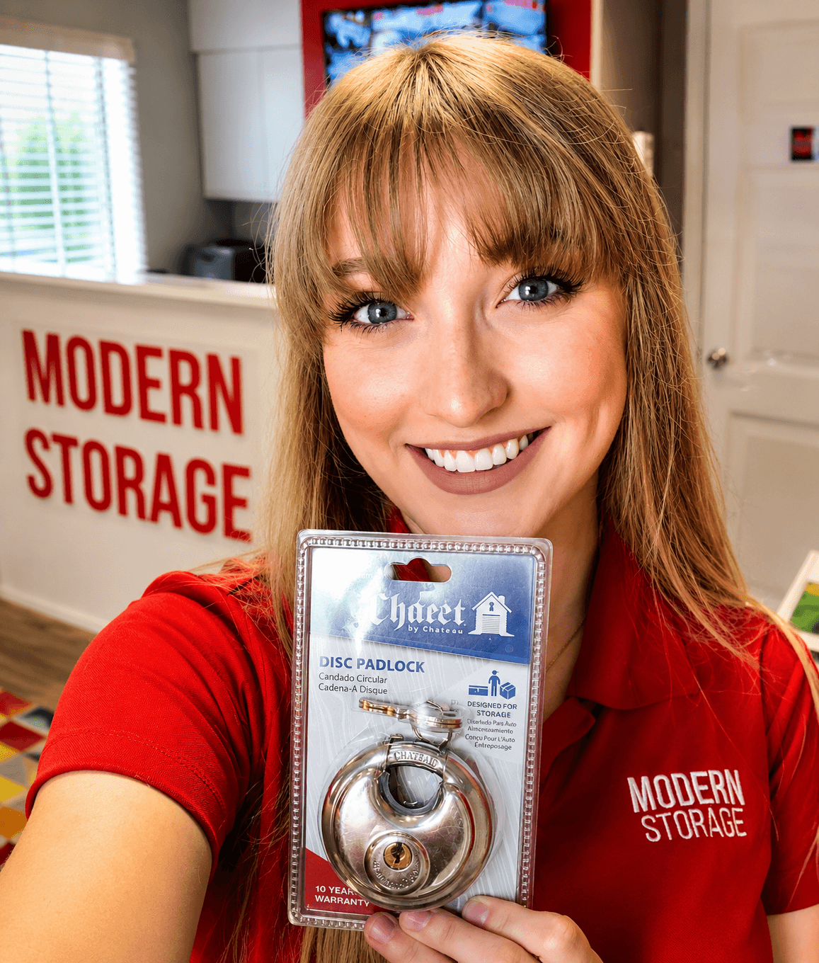 Modern Storage team member showcasing a high-security disc padlock available to help protect your storage unit.