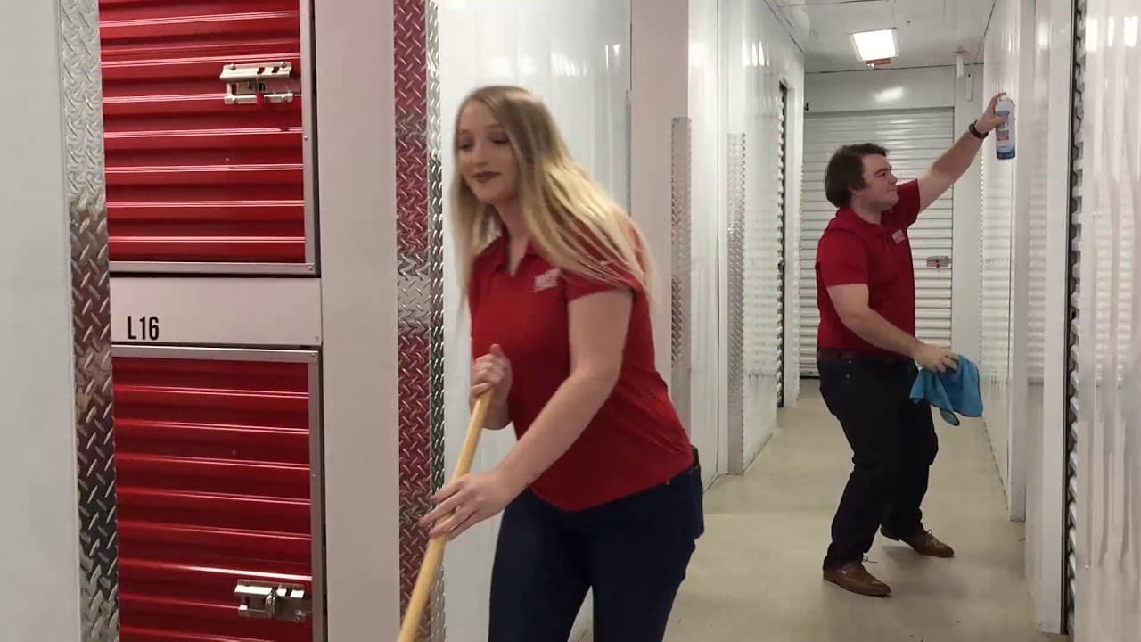 Two employees decluttering and organizing inside a Modern Storage® hallway as part of a spring cleaning clean-out challenge.