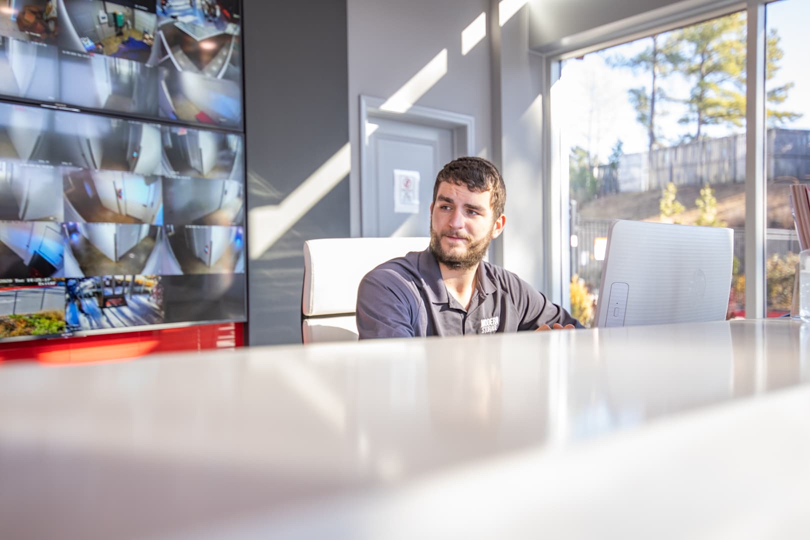 Modern Storage team member monitors live security cameras from the front office to help keep customer belongings safe.