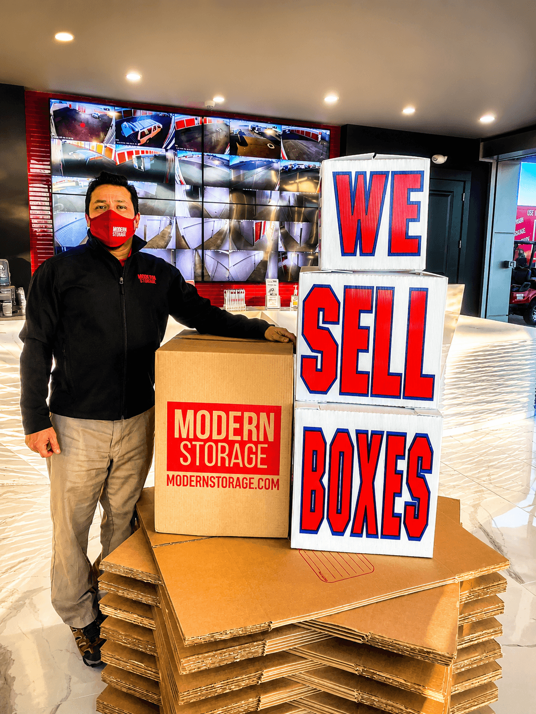 Modern Storage team member during covid19 displaying moving boxes and packing supplies available in the lobby.